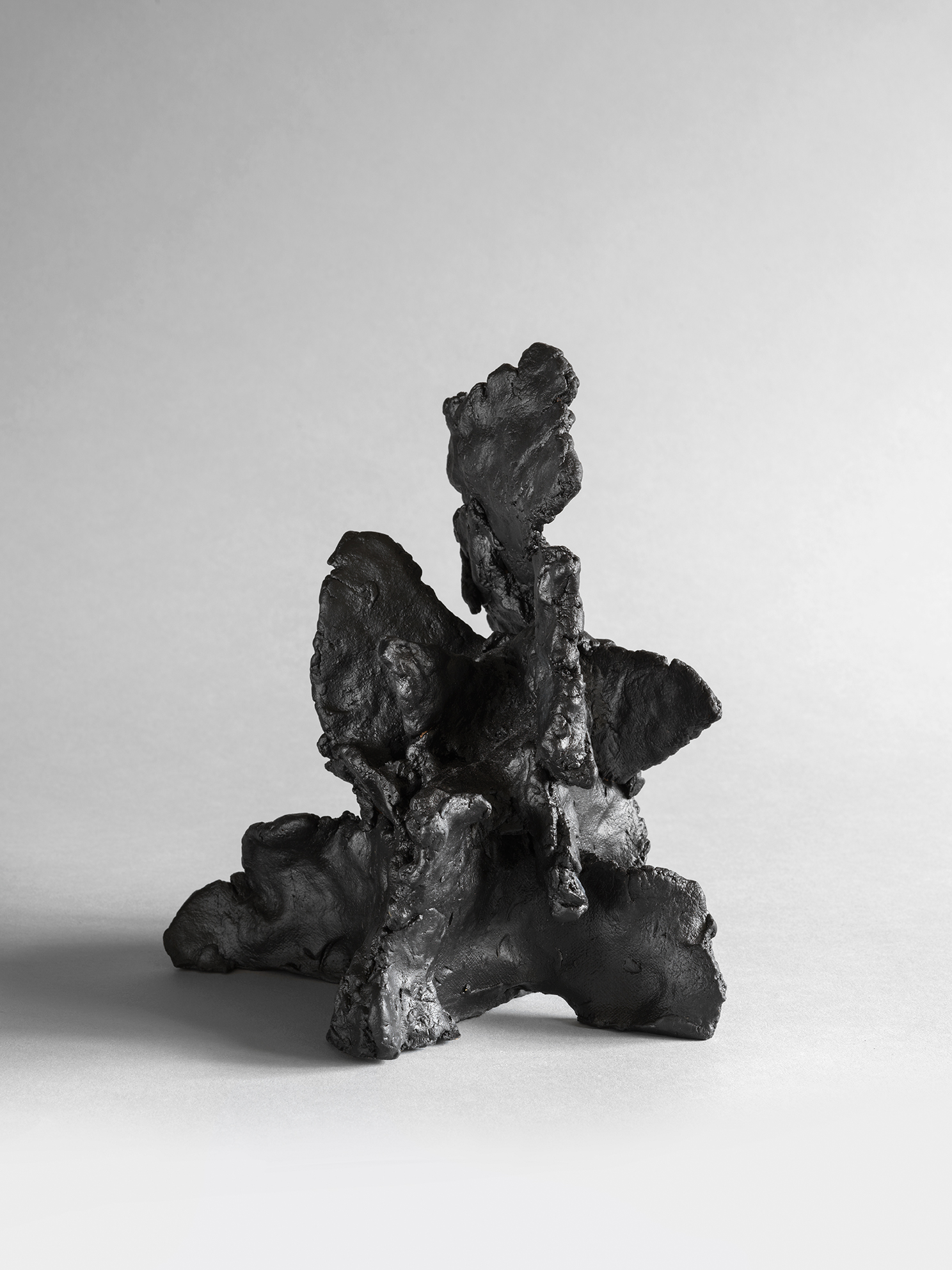 Black stoneware sculpture with stacked vertical forms creating a tiered tower-like structure